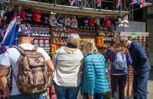 Tourists crowd round a stall selling souvenirs in London's Oxford Street Tourists crowd round a stall selling souvenirs in London's Oxford Street london memorabilia stock pictures, royalty-free photos & images