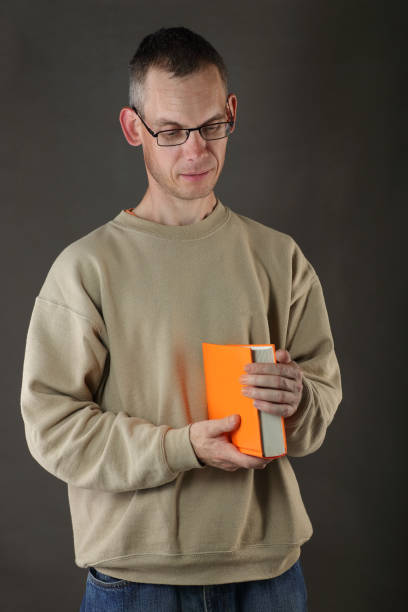 istock young person holding an orange book 1401146956