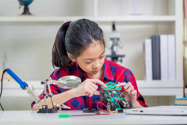 istock Child girl student build robotic cars, kid learning programming robot vehicles 1401147353