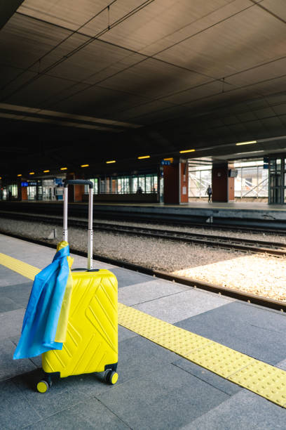 istock yellow valise with ukrainian flag at railway station 1401148540