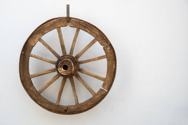 istock Vintage wooden cartwheel hangs on a white wall 1401152101