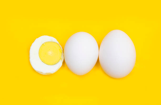 istock whole eggs and boil egg isolated on yellow background,top view 1401152194
