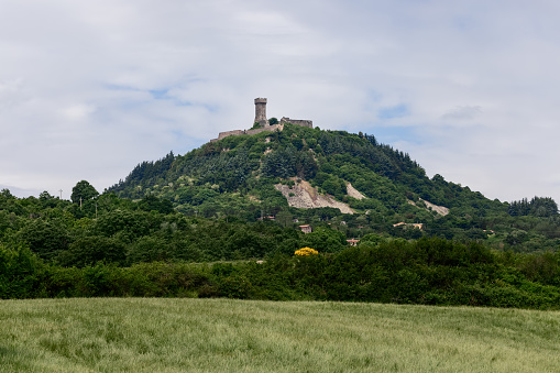 Tuscany - Italy. June 05, 2021: Rocca of Radicofani fortress on the top of a green Tuscan hill from. Italy