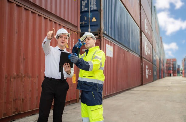 istock Dock manager and engineer worker in safety helmet point to the container in shipping yard during with copy space. Import and export product. Manufacturing transportation and global business concept 1401154043