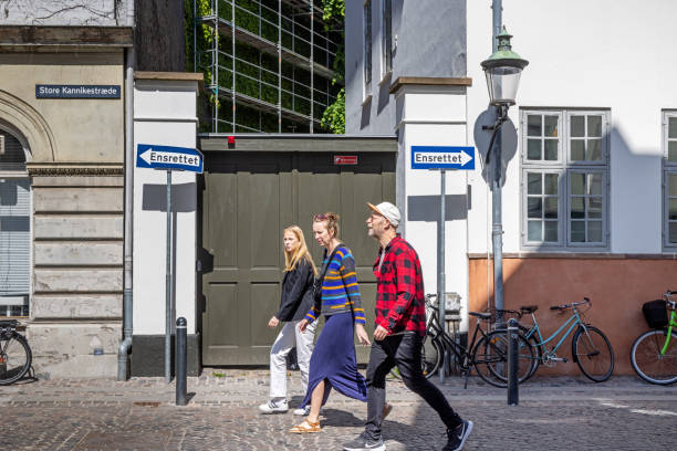 Tourists in front of traffic signs saying one-way street in Danish Family of tourists in front of a gate and traffic signs saying on way street in Danish in the center of Copenhagen zealand denmark stock pictures, royalty-free photos & images