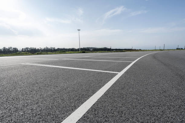 una plaza de aparcamiento sobre asfalto - highway asphalt road empty fotografías e imágenes de stock