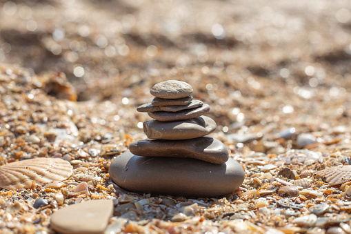 Pyramid of stones laid out on a sandy beach, selective focus. Relaxation and balance.