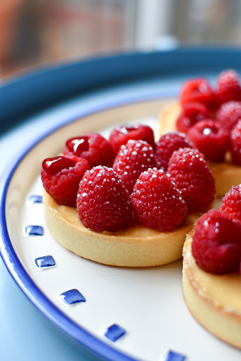 Tartlets with pastry cream and jam filled raspberries