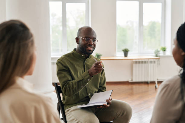 istock Young confident black man with notebook pointing at one of patients 1401165985
