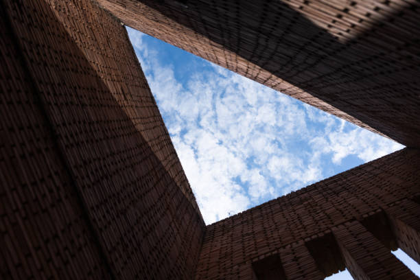 Red brick geometric building on blank cloud blue sky