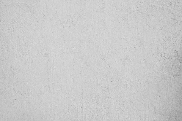 istock Gray paint plaster with cracks and specks, concrete wall outdoors. Textured rough background 1401169479