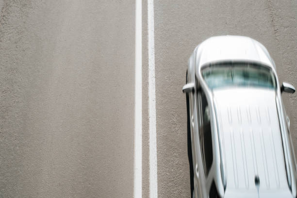 istock Silvery car driving at fast speed on road, top view. Blurred fast motion, selective focus on dividing double solid marking line on asphalt, copy space 1401169694