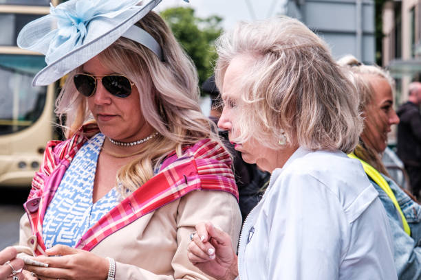 mujer con un sombrero turquesa blue fascinator comprando un boleto - people personal accessory town hat fotografías e imágenes de stock