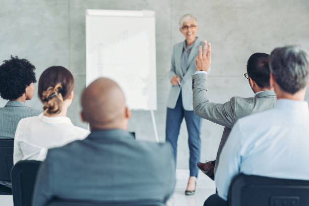 istock Focus on a businessman raising his hand during a conference 1401171012