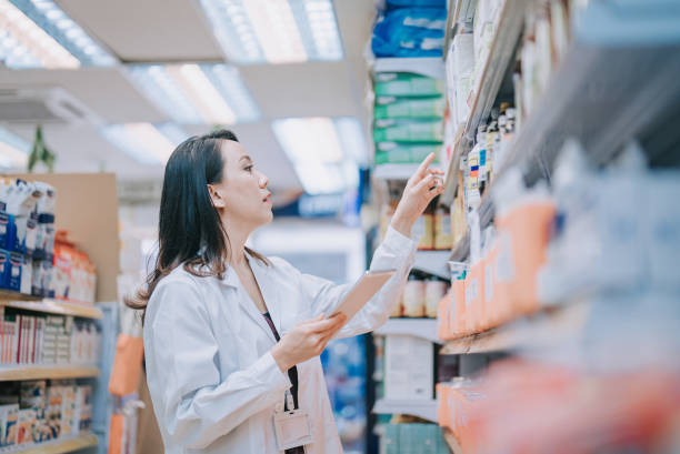 azjatycka chińska farmaceutka sprawdzająca zapasy na półce w aptece detalicznej - counting instrument zdjęcia i obrazy z banku zdjęć