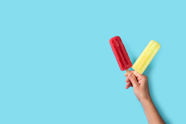 istock Hand holding a strawberry and lemon popsicles 1401177159