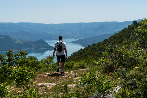 Man trekking in the view of Kızılırmak River in the canyon in Vezürköprü, Samsun province, Black Sea Region. \nThe view of the Kızılırmak River can be seen from the summit of the mountain. The wooded area was shot with a full frame camera in sunny weather.