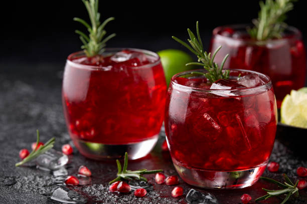istock Pomegranate gin cocktail with lime, rosemary and ice on rustic black table 1401177664