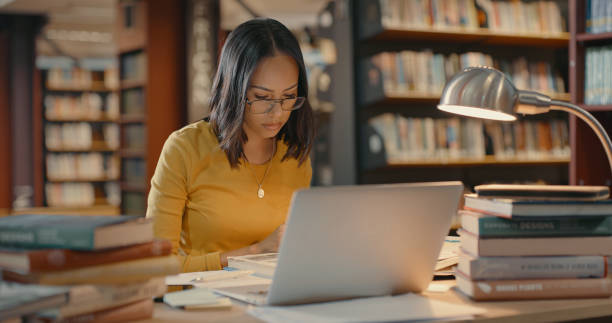 istock Mixed race female using a laptop and doing research. Young woman using a laptop and working on a project. Lawyer sending emails to team member 1401178936