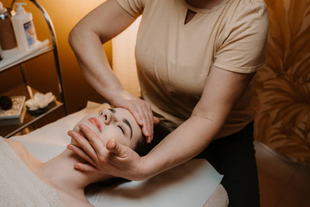 istock Massage therapist performing head massage on young woman 1401180667