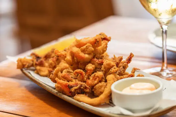 Mixed fried seafood with shrimp, squid and baby octopus and sauce mayonnaise (fritto misto di mare), typical italian appetizer