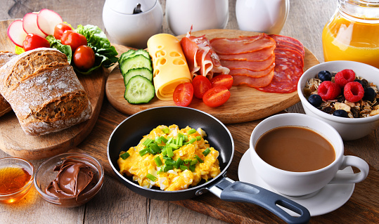 Breakfast served with coffee, orange juice, scrambled eggs, cereals, ham and cheese.