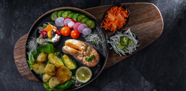 istock Fried salmon with potatoes and vegetable salads 1401183593