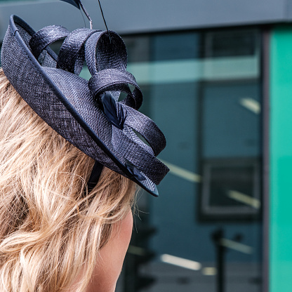 Epsom Surrey, London UK, June 04 2022, Rear Head Shot Of Young Woman Wearing Navy Blue Fascinator Hat