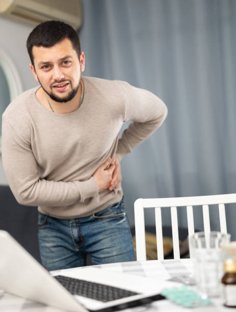 istock Young man suffering from colic in left side at home 1401200403