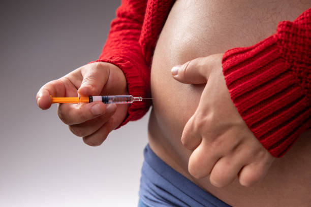 una mujer embarazada se inyecta un anticoagulante con una jeringa - diabetes insulin human fertility injecting fotografías e imágenes de stock