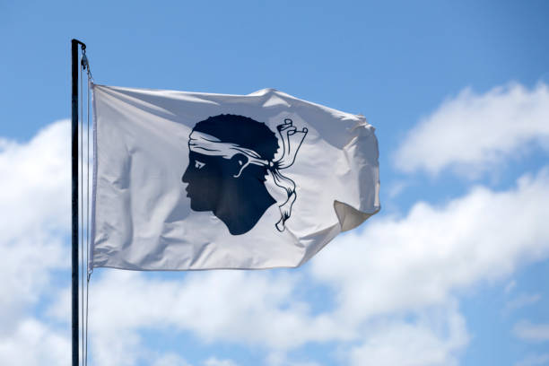 Flag of Corsica Flag of Corsica waving atop of its pole. corsican flag stock pictures, royalty-free photos & images