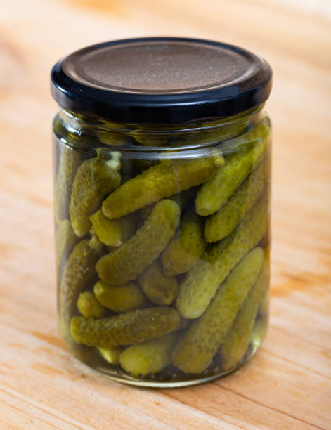 istock Glass jar with pickled cucumbers on a wooden table 1401206582