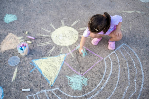 la linda niña dibujando la imagen en el suelo - little girls sidewalk child chalk fotografías e imágenes de stock