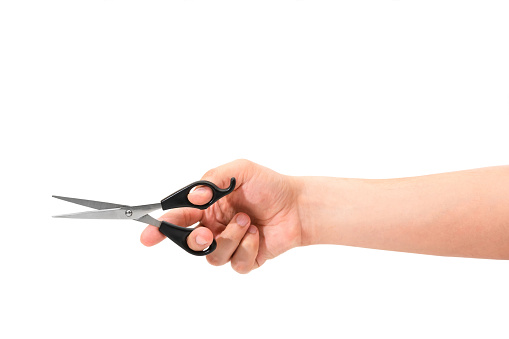 Hand holding scissors isolated on white background.