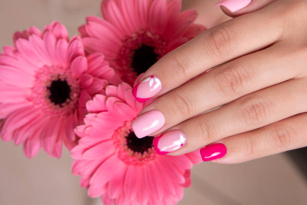 istock Female hands with pink manicure, flowers design 1401213339