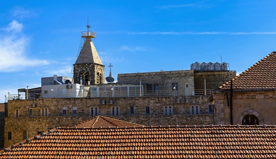 East Jerusalem, Palestine, May 5, 2019: View of a bell tower on the roofs of the Christian Quarter of the Jerusalem Old City. The Old City is listed as UNESCO World Heritage Site.