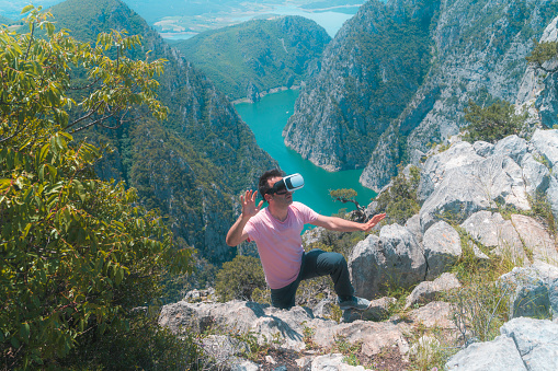 Man wearing a virtual reality simulator at the summit of Şahinkaya canyon in Vezürköprü, Samsun province, Black Sea Region. The view of the Kızılırmak River can be seen from the summit of the mountain. The view of the canyon was taken with a full frame camera in sunny weather.