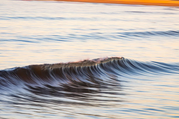 istock Small ocean wave breaking during a soft sunrise at the beach 1401217699