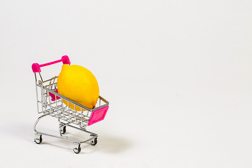 Lemon in a grocery trolley on a white background
