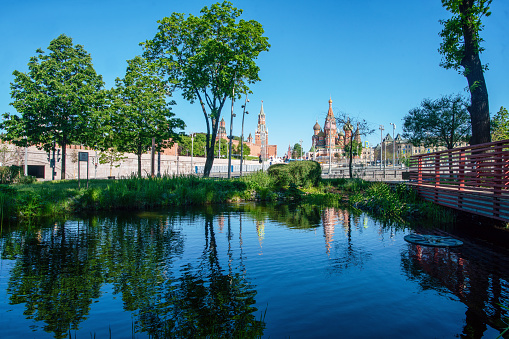 Zaryadye park  and  Kremlin fortress and     St. Basil 's Cathedral  in Moscow  with  pond   and reflections  -   amazing   summer