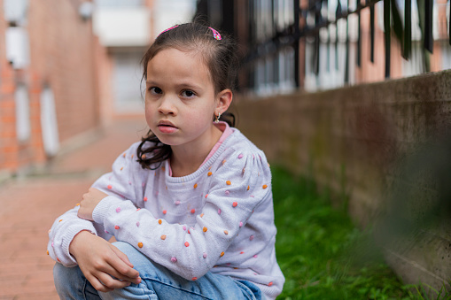 Cropped close up portrait of serious sad little girl looking at camera, unhappy little orphan girl feeling lonely abandoned, outcast or lonely miss parents, childhood drama, volunteer concept