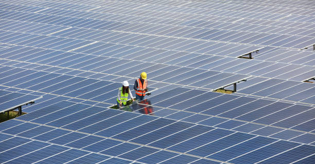 ソーラーパネル、再生可能エネルギーとグリーンエネルギーの概念を検査する安全ppe作業を身に着けているソーラーエンジニア - 電球形蛍光灯 ストックフォトと画像