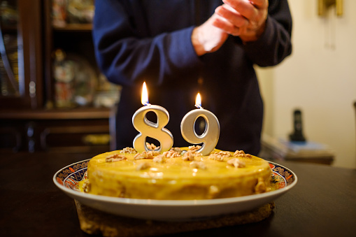 birthday cake with the number 89 with the old man who has years behind blurred
