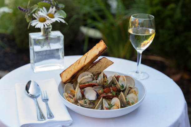 A clam and pasta dish with wine in outdoor setting A clam and pasta dish with wine in outdoor setting in Chatham, Massachusetts, United States cape cod stock pictures, royalty-free photos & images