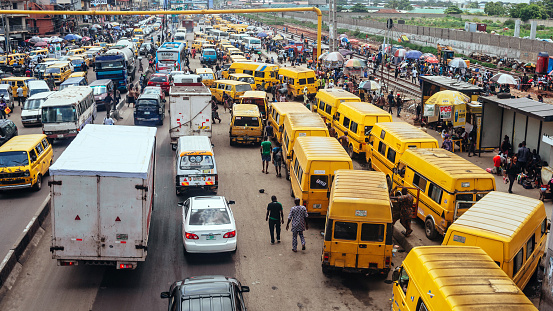 Yellow public transport danfos in traffic.\nLagos, Nigeria, West Africa