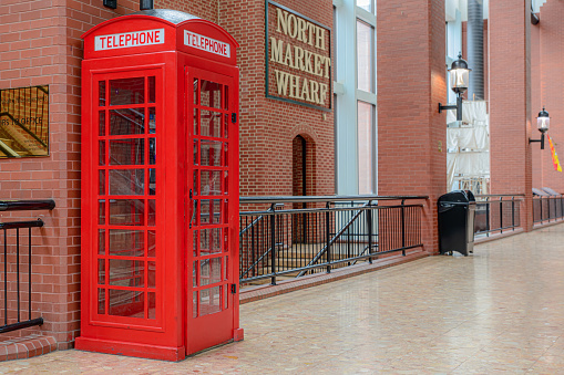 Saint John, NB, Canada - June 5, 2022: A red phone booth. The booth is the famous British K6 design, but without the crown at the top.