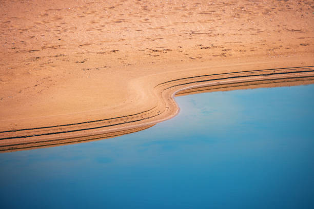 Oasis in a desert. Sand and water, prints of waves.