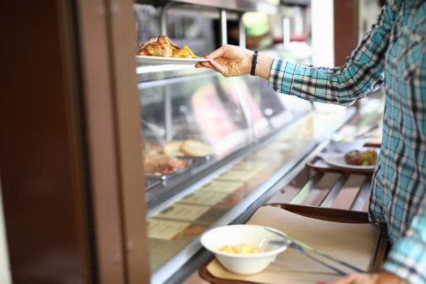 femme prenant l’assiette avec déjeuner à la cantine - cantine photos et images de collection