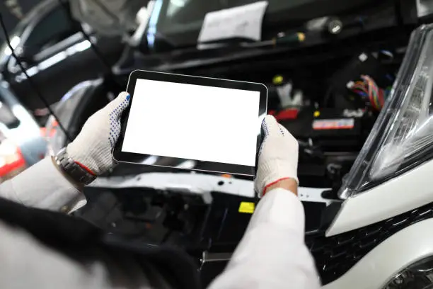 Photo of Mechanic worker using tablet for diagnostics of technical condition of vehicle