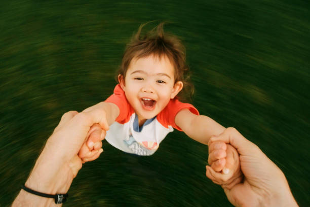 istock Toddler Swinging on Father's Arms 1401241399